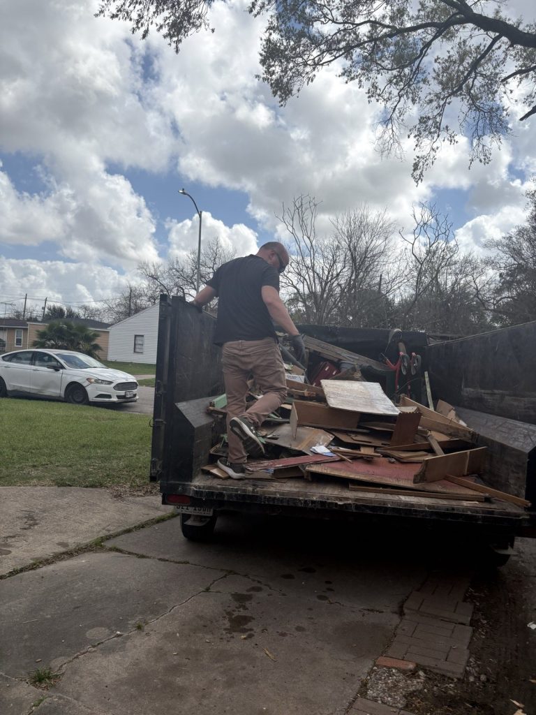 Loading debris into a dump trailer in a driveway